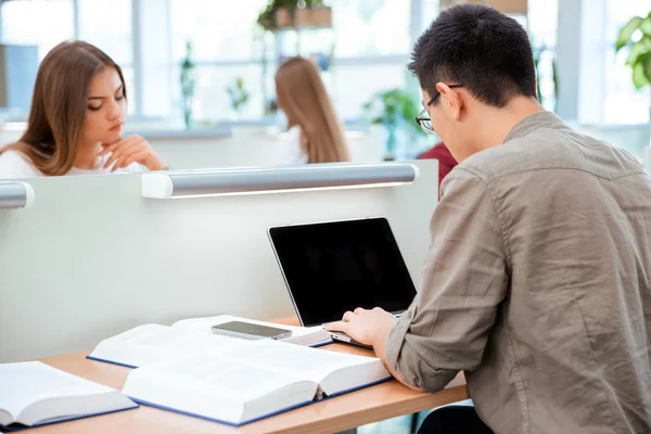 Uczeń korzysta z laptopa w bibliotece — Zdjęcie stockowe