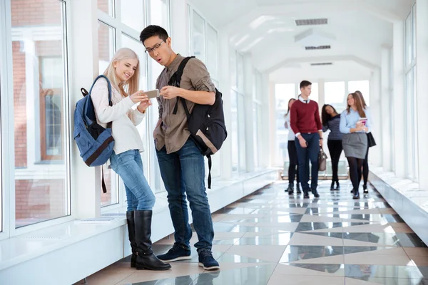 Studenten met behulp van smartphone in de hal van de Universiteit — Stockfoto