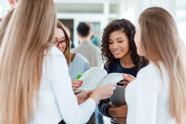 Studenten praten over boek in Universiteit hall — Stockfoto