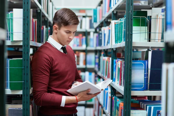 Livro de busca de estudantes na biblioteca universitária — Fotografia de Stock