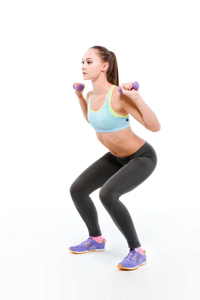 Joven deportista en cuclillas con mancuernas —  Fotos de Stock