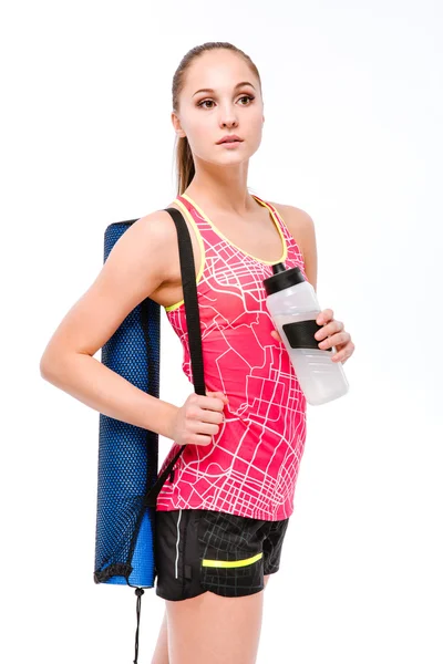 Ung sportsdame med yogamåtte og flaske vand - Stock-foto