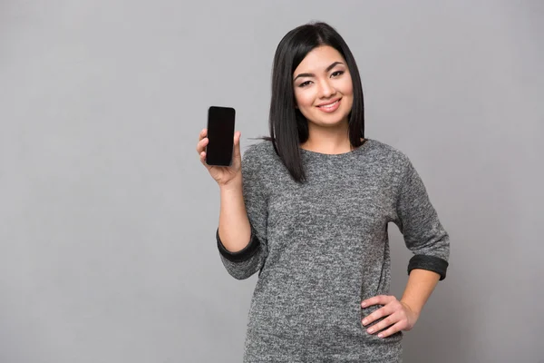 Mulher mostrando tela de smartphone em branco — Fotografia de Stock
