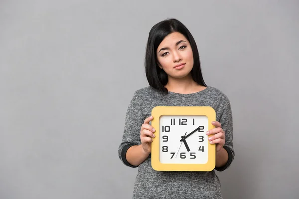 Retrato de una mujer triste sosteniendo reloj de pared — Foto de Stock