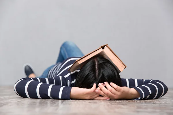 Jovem cansada dormindo com livro no rosto — Fotografia de Stock