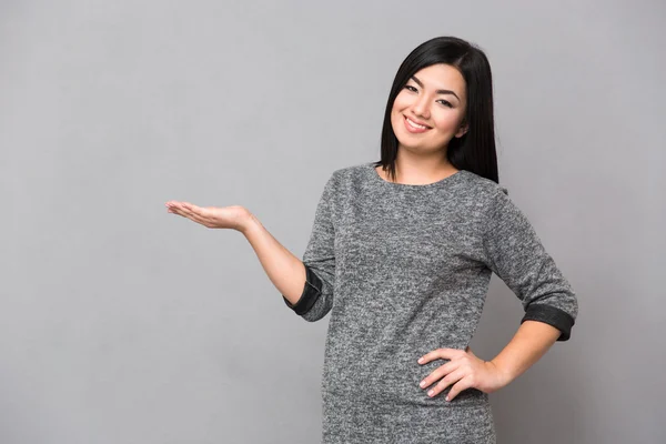 Asiática chica sosteniendo copyspace en la palma —  Fotos de Stock