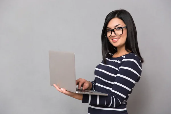 Retrato de una mujer feliz usando un portátil — Foto de Stock