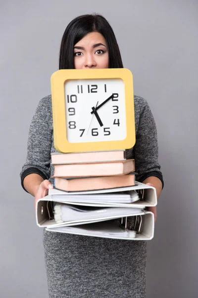 Mulher segurando livros, pastas e relógio de parede — Fotografia de Stock