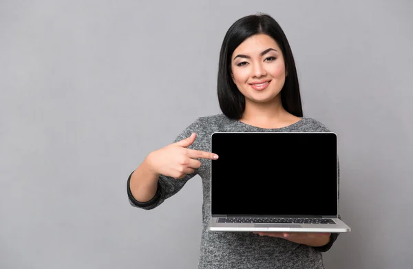 Mujer señalando dedo en la pantalla del ordenador portátil en blanco —  Fotos de Stock