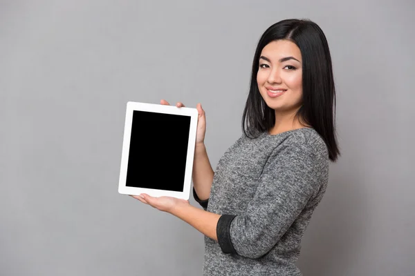 Femme souriante montrant écran de tablette — Photo
