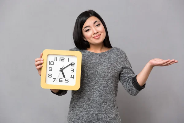 Mujer sosteniendo reloj de pared y copyspace en la palma — Foto de Stock