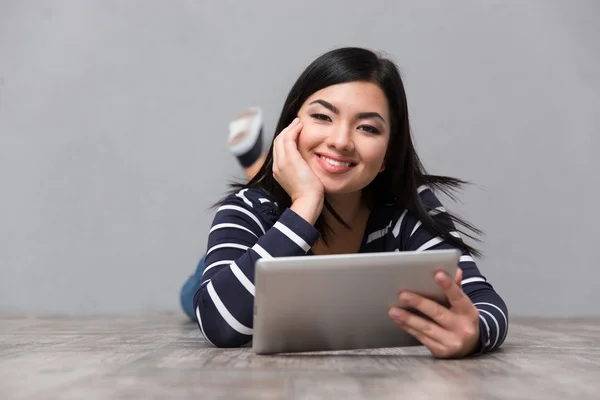 Mulher deitada no chão com tablet — Fotografia de Stock