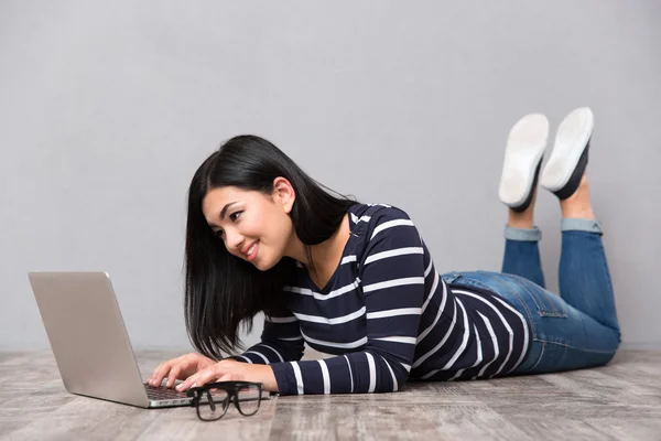 女人躺在地板上，使用便携式计算机 — 图库照片