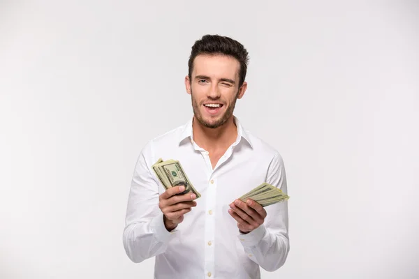 Mann hält Dollarscheine und zwinkert — Stockfoto