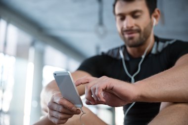 Akıllı telefon kullanan spor salonunda fitness adam