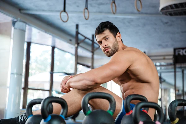 Sportsman sitting near kettle balls — Stock Photo, Image