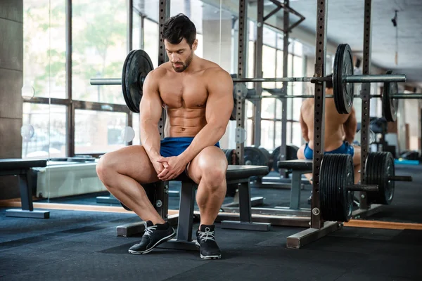 Mann ruht sich in Fitnessstudio auf Bank aus — Stockfoto