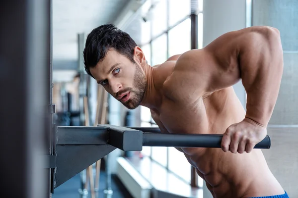 Muscular homem treino em barras paralelas — Fotografia de Stock