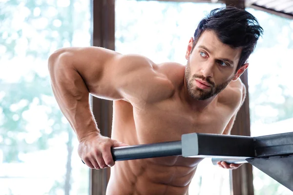 Male bodybuilder workout on parallel bars — Stock Photo, Image