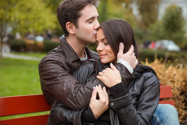 Casal abraçando ao ar livre no banco — Fotografia de Stock