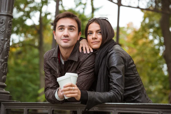Couple standing with coffee outdoors — Stock Photo, Image