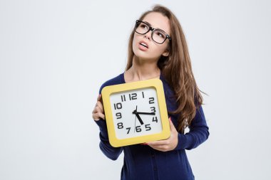 Duvar saati tutan düşünceli sevimli kadın