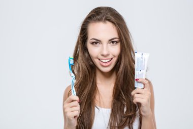 mutlu bir kadın tutarak diş fırçası ve diş macunu
