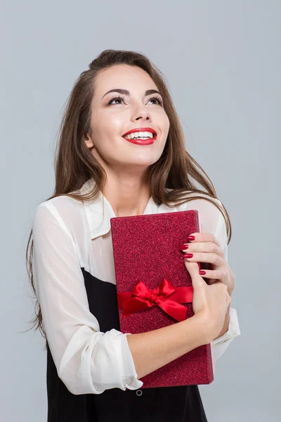 Бізнес-леді тримає подарункову коробку і дивиться вгору — стокове фото