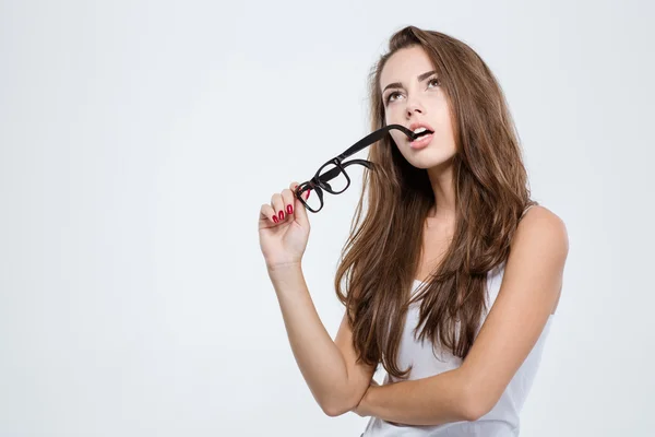 Eftertänksam kvinna håller glasögon och letar upp — Stockfoto