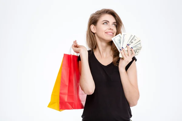Mulher feliz segurando sacos de compras e dinheiro — Fotografia de Stock