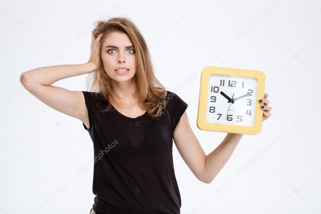 Nervous woman holding wall clock