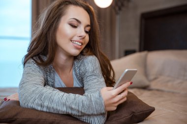 Yatakta yatıyordu ve smartphone kullanarak kadın