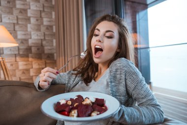 Genç kadın yemek yemek için ağzını açtı