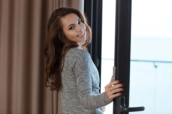Lachende meisje in de buurt van het venster — Stockfoto