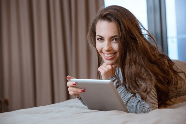 Menina feliz que coloca e usando tablet — Fotografia de Stock