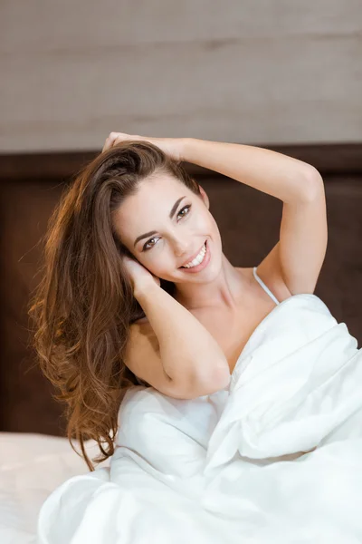 Donna seduta sul letto con coperta — Foto Stock