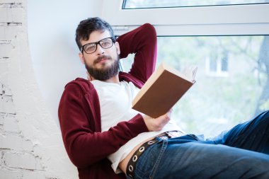 Öğrenci pencere pervazına üzerinde oturan ve gönüllülük gözlük