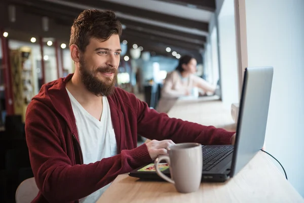 Felice hipster che lavora in ufficio utilizzando il computer portatile — Foto Stock