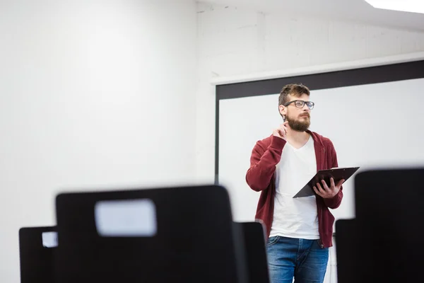 Jonge leraar permanent in de buurt van het whiteboard in klas — Stockfoto