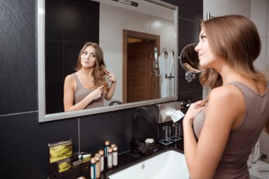 Güzel erkek saç fırçalama sırasında aynaya bakıyorum