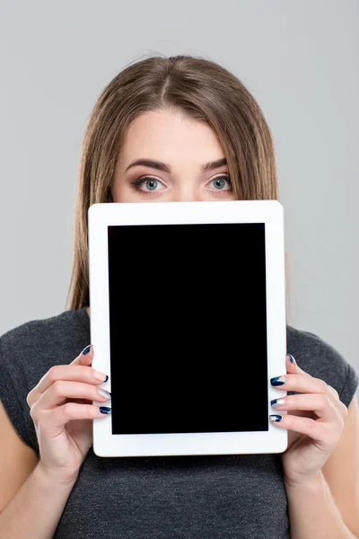 Mujer cubriendo su cara con la pantalla de la tableta en blanco — Foto de Stock