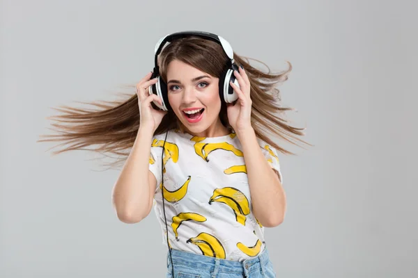 Mujer alegre escuchando música en auriculares — Foto de Stock