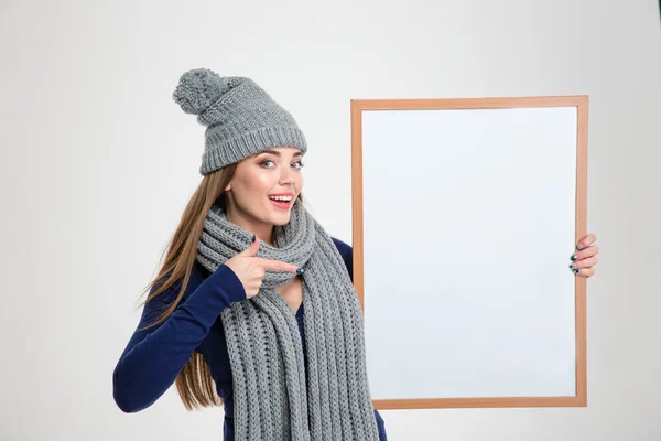 Happy woman pointing finger on blank board — Stock Photo, Image