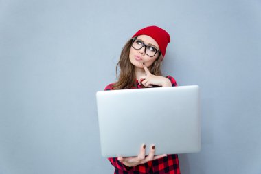 Laptop ile duran dalgın hipster kadın