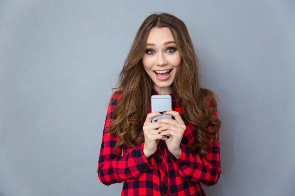 Cheerful woman holding smartphone