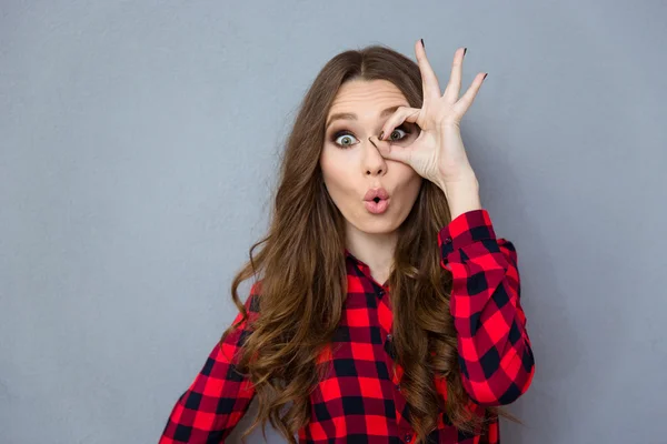 Funny curly girl showing okay gesture near her eye — Stock Photo, Image