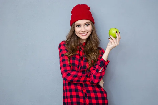 Frau hält Apfel in der Hand und blickt in Kamera — Stockfoto