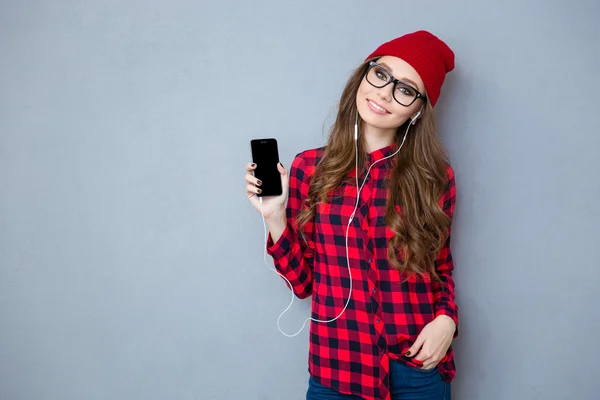 Femme tenant un smartphone et écoutant de la musique dans un casque — Photo