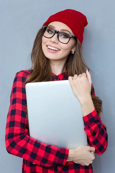 Sonriente mujer hipster sosteniendo ordenador portátil —  Fotos de Stock