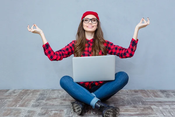 Mujer sentada en el suelo con ordenador portátil y meditando —  Fotos de Stock